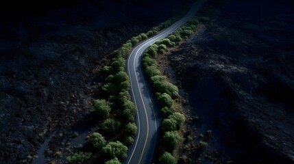 Fototapeta premium Aerial view of winding road along rugged volcanic landscape with lava terrain