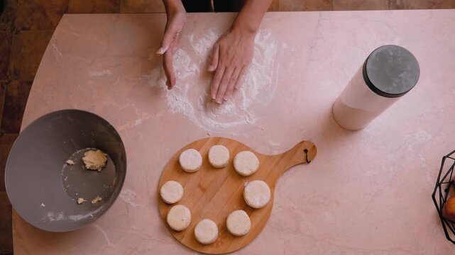 Kneading and shaping dough. Flattening and forming dough into tiny bread buns on work surface. Dusting with flour and shaping dough into miniature buns on countertop before baking