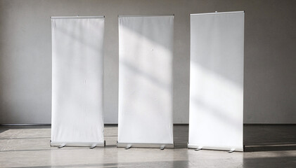Three blank roll up banners stand tall in a light filled contemporary room