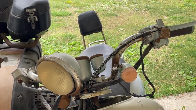 Vintage motorcycle with sidecar parked outdoors, showcasing retro design and aging details