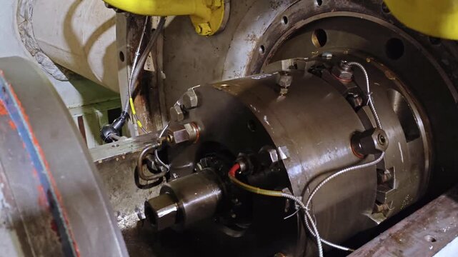 Industrial rotor disassembled for detailed inspection, exposed bearings and shaft with wiring and sensors attached, workshop diagnostic setup for vibration and temperature analysis during maintenance