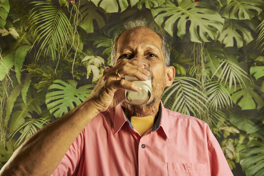 Senior man drinking milk with tracheostomy medical patch