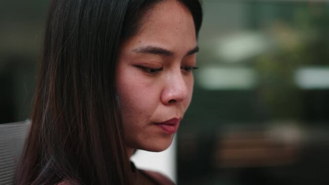 Thoughtful woman using an electronic cigarette and exhaling vapor outdoors