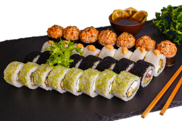 Sushi platter with black tobiko green rolls crunchy gunkan maki on slate © smslov