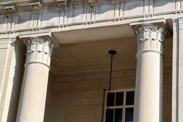 Sun-drenched classical stone columns with ornate capitals and intricate architectural details, showcasing historical grandeur, strong shadows, and a timeless elegant facade. © Michael