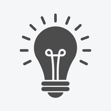 Simple light bulb shines brightly radiating light with energy, symbolizing an innovation or idea