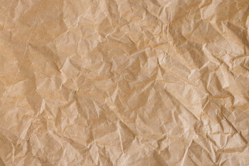 Obraz premium Crumpled Brown Kraft Paper Texture Background,Close-up top view of wrinkled and crumpled brown kraft paper texture. Abstract background of rough recycled paper surface with organic creases and folds, 