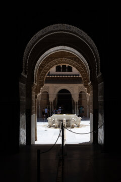 View through ornate arch to Fountain of the Lions in Alhambra, Granada, Spain