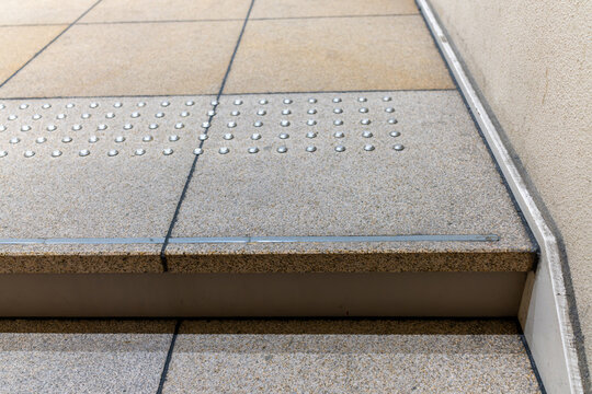 シルバーのドット状点字鋲が埋め込まれたグレーの石床