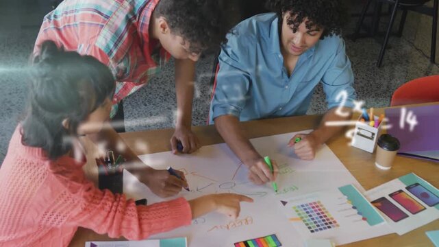 Vertical video: Blue shirt drawing center circle, trio refining sheet at table with markers to plan