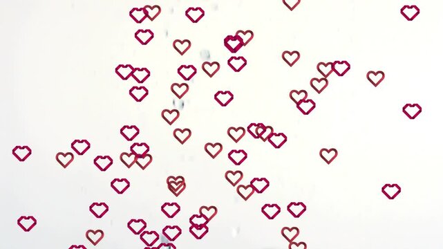 Drifting red pink heart outlines spreading across mid frame on white backdrop with central bubbles