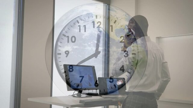 Man talking on phone gesturing at laptop and board, clock overlay advancing discussing business
