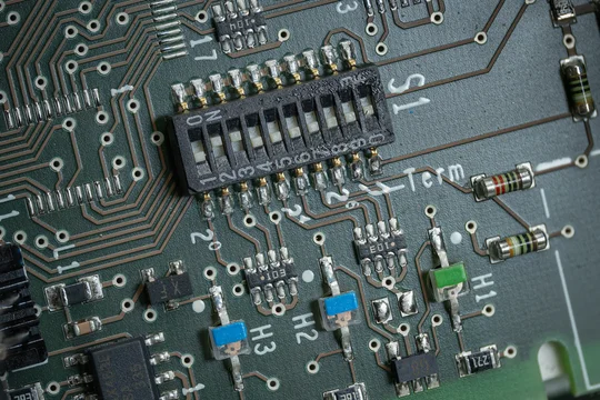 A close-up of a DIP switch with LED diodes on a printed circuit board.