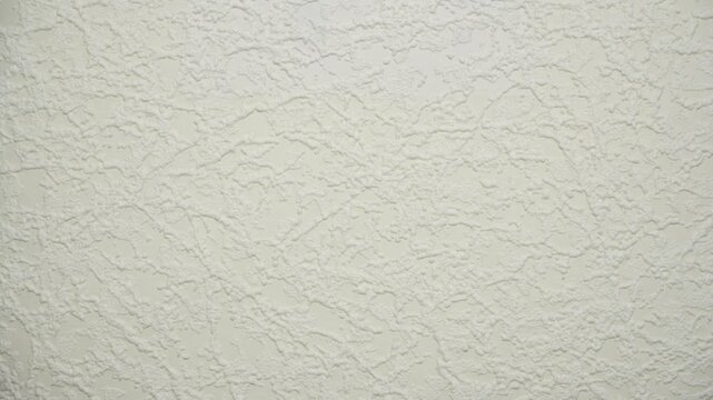 Close-up of a paintable wallpaper catalog being flipped through, revealing various textured surface patterns. Concept of interior design selection, renovation process and material samples