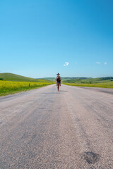 Obraz premium Lone cyclist rides down a sunlit road