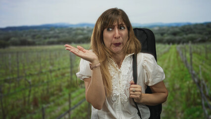 Naklejka premium Young woman grimacing with hand to nose and holding a bag strap in a forest vineyard scene; disgust.