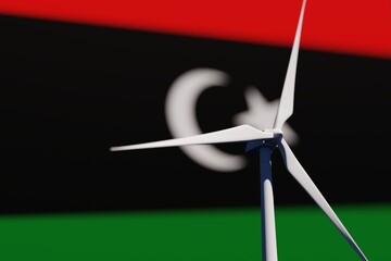 Wind turbine on a background of blurred flag of Libya. Wind power concept, selective focus © Hairem