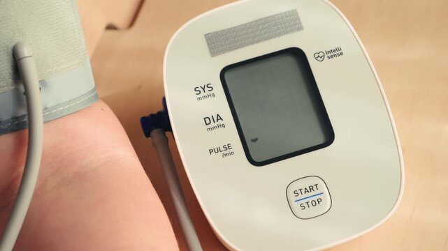 Hand using automatic tonometer for blood pressure checking. High quality 4k footage