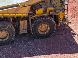 Fototapeta premium Aerial view of a CAEX mining truck traveling along a mining road towards the bottom of an open pit mine