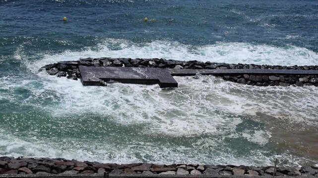 Large waves from Storm Therese impacting coastal area and shoreline infrastructure.