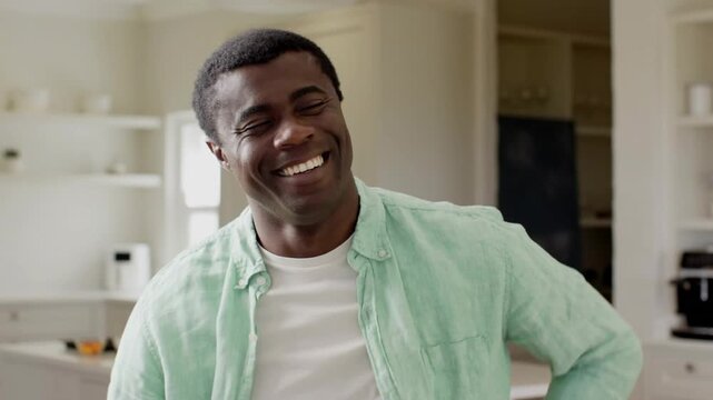 Man in kitchen smiling then laughing while gold confetti falling, hiding face, clearing, ads