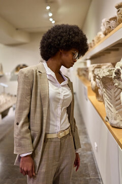 Woman wearing glasses and looking at exhibition. Concept of Museum Day.