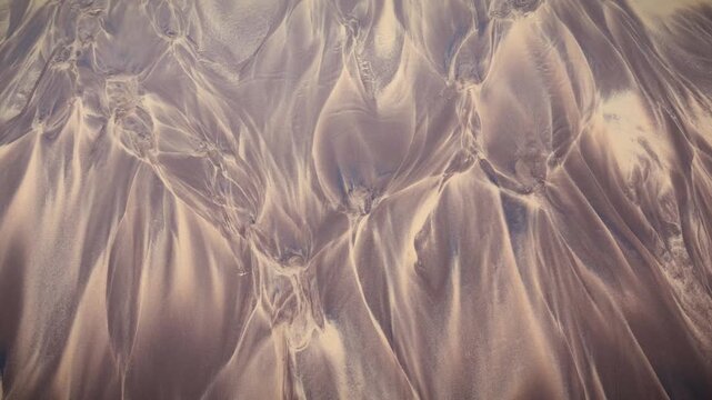 Mumbai Maharashtra India Jan 18 2026 Abstract top view of flowing sand and water patterns at Juhu Beach showing natural textures smooth curves and organic formations created by receding tide.