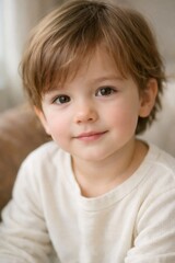 Fototapeta premium Young boy looking directly at the viewer with warm brown eyes and a sweet, innocent smile, portraying childhood, happiness, and genuine emotion, perfect for family and lifestyle themes