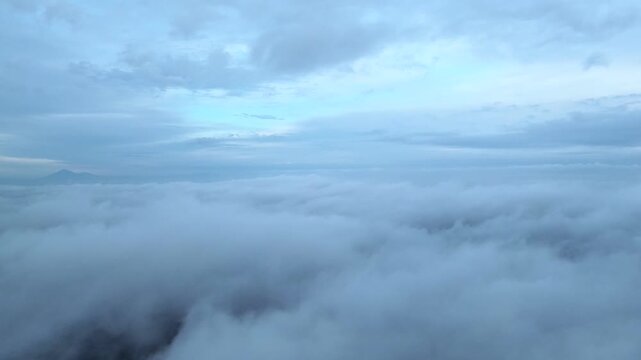 Professional 4K aerial drone footage of descending through fog revealing residential houses homes Indonesia for cinematic morning scenes, atmospheric rural content, ethereal storytelling, and design.