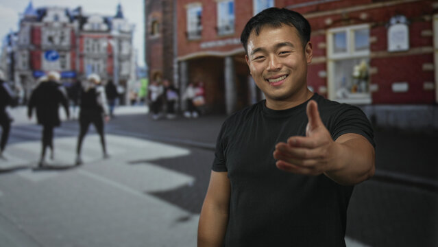 Man extends hand for handshake on a busy city street with blurred pedestrians behind him; friendship.