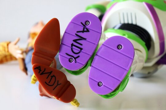 Salvador, Brazil - March 20, 2026: Close-up of the feet of Woody and Buzz Lightyear action figures with 'Andy' written on the sole. Toy Story movie. 