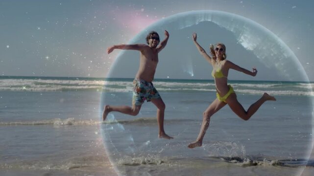 Man entering frame and globe glowing causing couple hopping and splashing on shore for travel