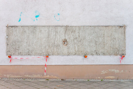 Wei&szlig; verputzte Wand mit Spuren eines abmontierten Schaukastens und rot-wei&szlig;er Markierung