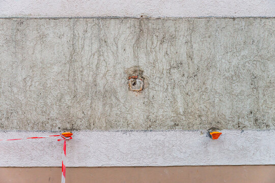 Wei&szlig; verputzte Wand mit Spuren eines abmontierten Schaukastens und rot-wei&szlig;er Markierung