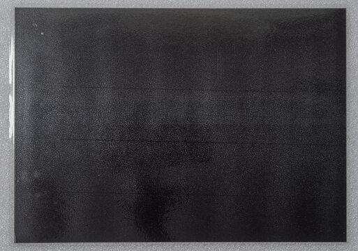 Gray laminated copy paper texture with glossy surface and subtle reflections, cool paper and foil overlay.	