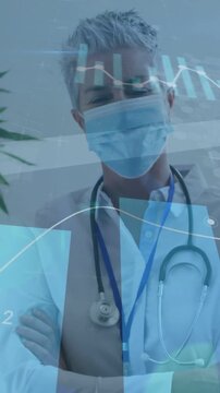 Vertical video: Senior doctor standing, data feed causing animated medical charts overlaying mask