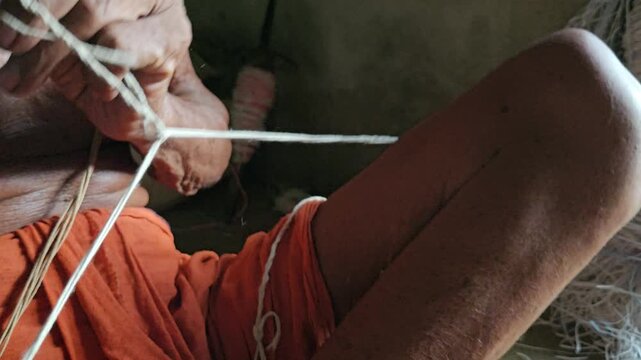 Elder Indian Brahmin making sacred thread janeyu by hand. Traditional Hindu ritual craft showing cultural heritage, spirituality, and authentic lifestyle.