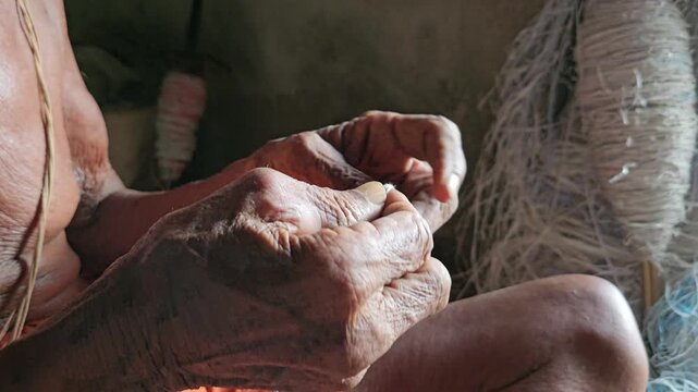 Elder Indian Brahmin making sacred thread janeyu by hand. Traditional Hindu ritual craft showing cultural heritage, spirituality, and authentic lifestyle.