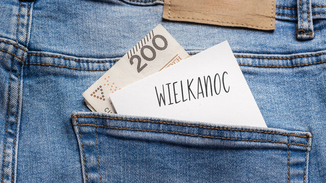 Polish banknotes with a face value of 200 zlotys and a white card with the inscription "Wielkanoc" protruding from the back pocket of blue jeans.