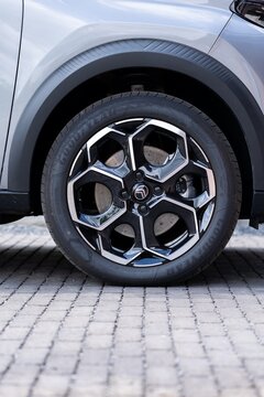 Brecht Belgium - 10 October 2025 Macro shot of car wheel with Goodyear tire and shiny alloy rim, showcasing brake disc, texture, and urban cobblestone surface.