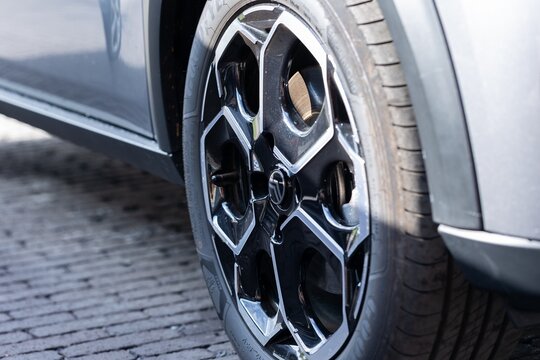 Brecht Belgium - 10 October 2025: Automotive closeup of glossy rim and Goodyear tire on cobblestone road, capturing reflections, tread pattern, and modern car aesthetics.