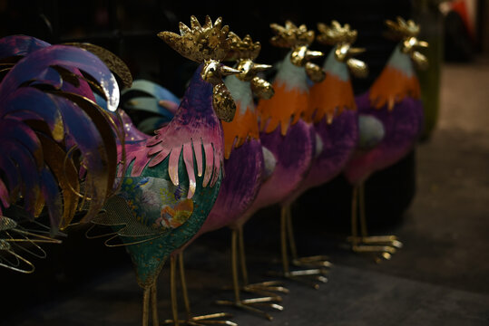 Easter holiday. Colorful metal roosters at a decor store.