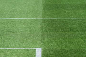 Obraz premium Well-Maintained Football Stadium Pitch with Striped Grass Under Clear Blue Sky
