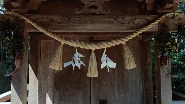Shimenawa sacred rope at Shinto shrine, traditional Japanese religious symbol close up