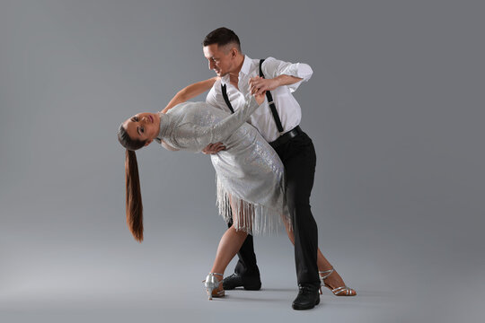 Couple of professional dancers on grey background