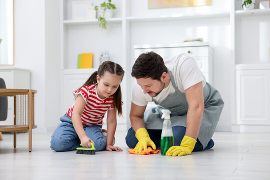 Spring cleaning. Father and daughter tidying up floor at home
