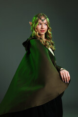 Naklejka premium Beautiful girl dressed as elf on grey background