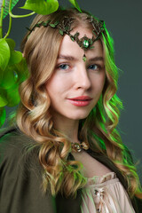 Naklejka premium Beautiful elf girl and green leaves on grey background