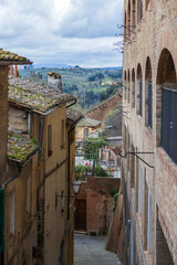 Obraz premium Winding Pathway With Rustic Brick Surrounds Leads To Scenic Views. Stone Alleyway Reveals Breathtaking Sights Of Countryside Beyond Quiet Passage
