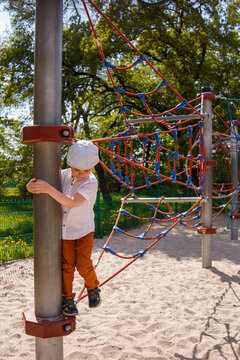 Boy climbing rope playground structure close up